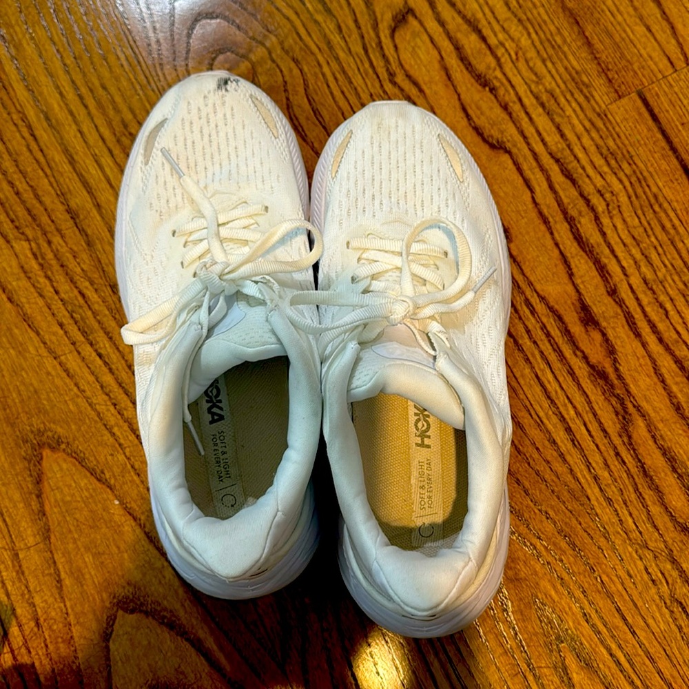 Hoka white tennis shoes. Black scuff. Mark on left toe.  Great shape though.
